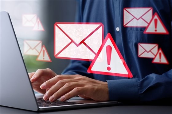 Person at computer with email and alert icons as a warning (JPG)